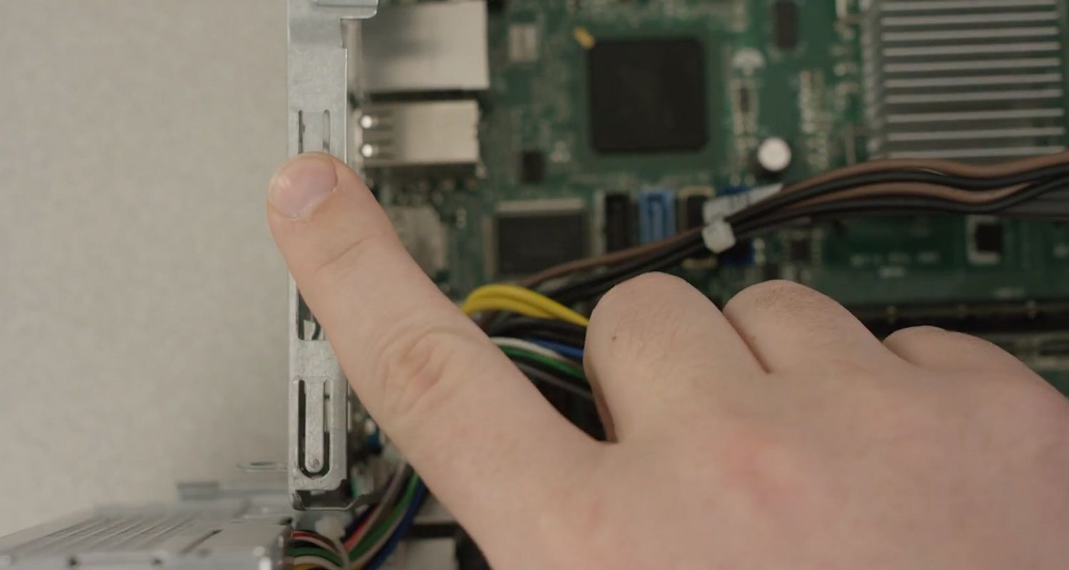 Fingerberührung einer unlackierten Metalloberfläche im Inneren eines Desktop-PCs zur Ableitung statischer Aufladung