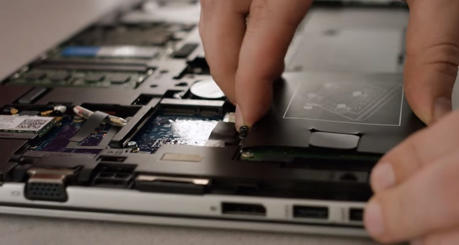 Crucial SSD, die in den Speicherschacht eines Laptops gesteckt wird