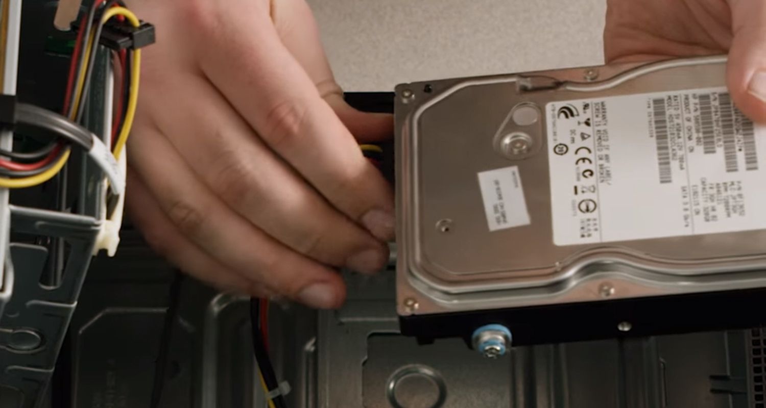 Person, die Kabel vom Speicherlaufwerk eines Desktop-Computers trennt